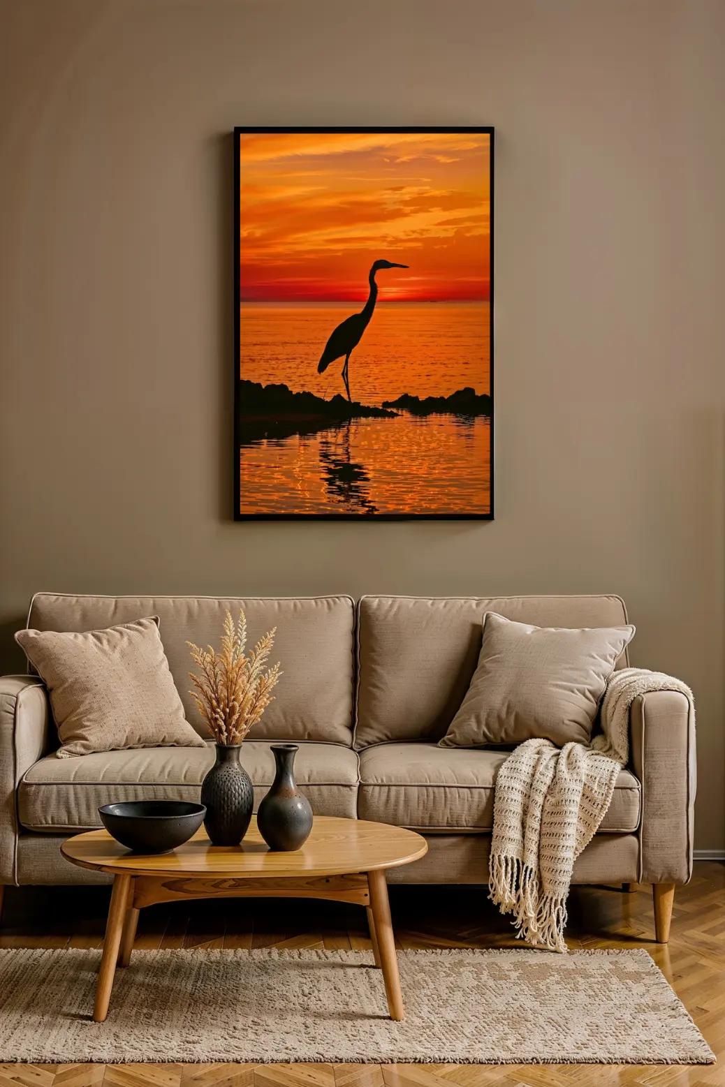 A stunning digital wall art print showing a heron silhouette at sunset. The bird stands on dark rocks by the ocean as a fiery, vibrant orange and red sky reflects in the water. This image, featured in our product review, is a tranquil coastal art piece, provided as a 300 DPI PNG instant download perfect for home decor.