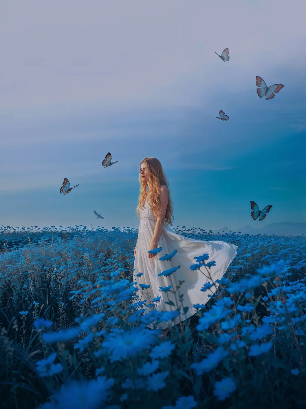 Vertical fantasy art inspiration showing a girl lost in a field of blue cornflowers. Her white dress contrasts sharply against the dark, moody blue background. She stands perfectly still, letting the wind and butterflies brush past her. This visual represents themes of mindfulness, silence, and introspection. Perfect for writers looking for story prompts or mood boards involving magical realism, dreamscapes, and serene, otherworldly nature settings.